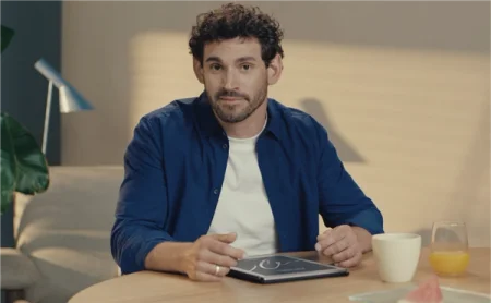 A man sitting at a table with a reMarkable Paper Pro on it.