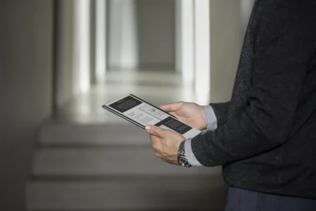 A man holding a reMarkable 2. The screen is showing the release notes for software version 3.3.